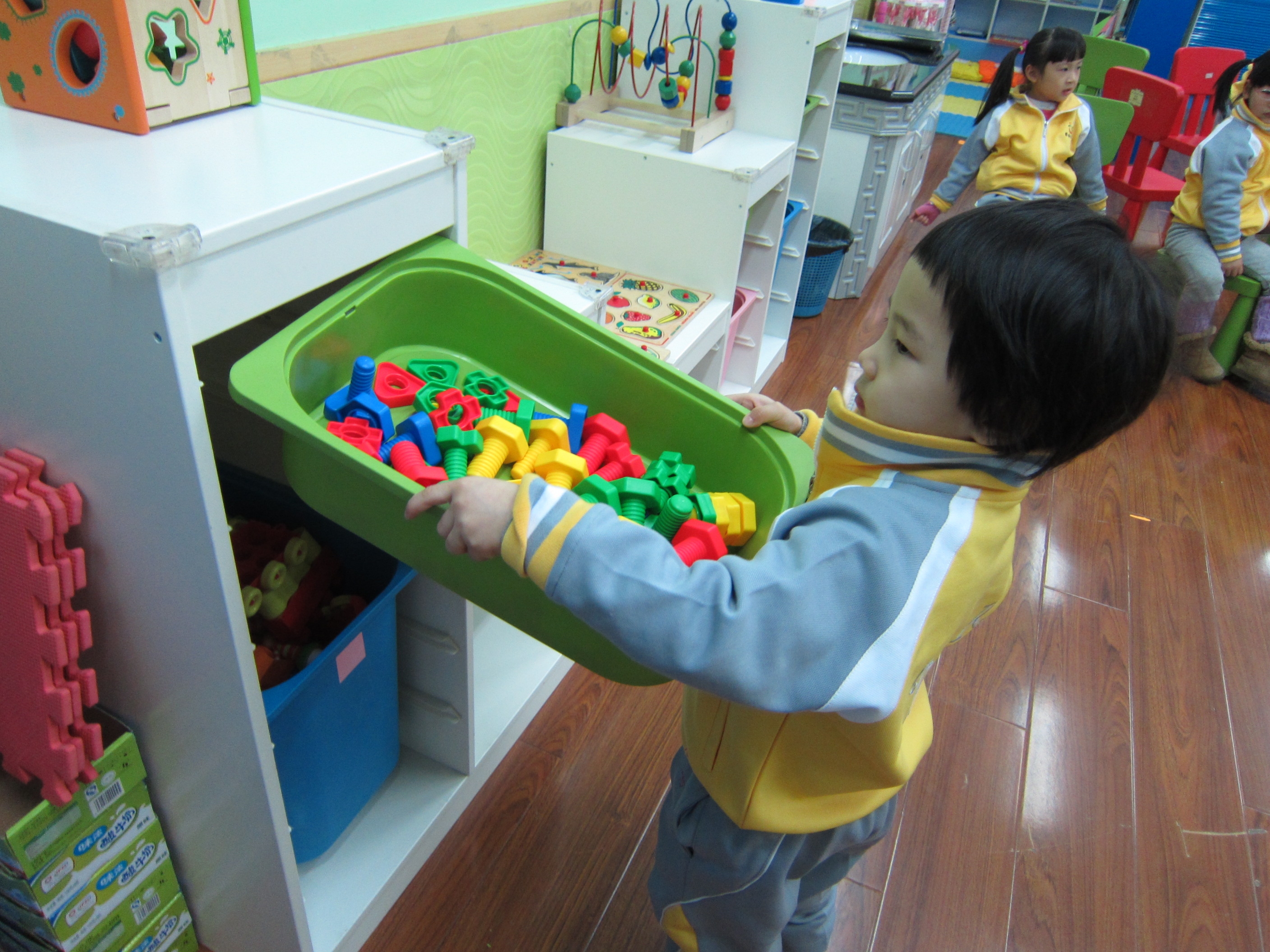 愛迪幼兒園學生整理玩具